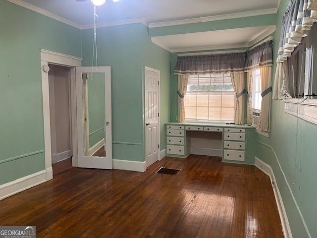 unfurnished bedroom with baseboards, crown molding, visible vents, and dark wood-type flooring