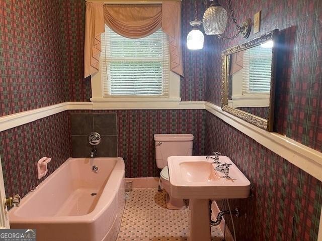 full bathroom with a wainscoted wall, a garden tub, and wallpapered walls