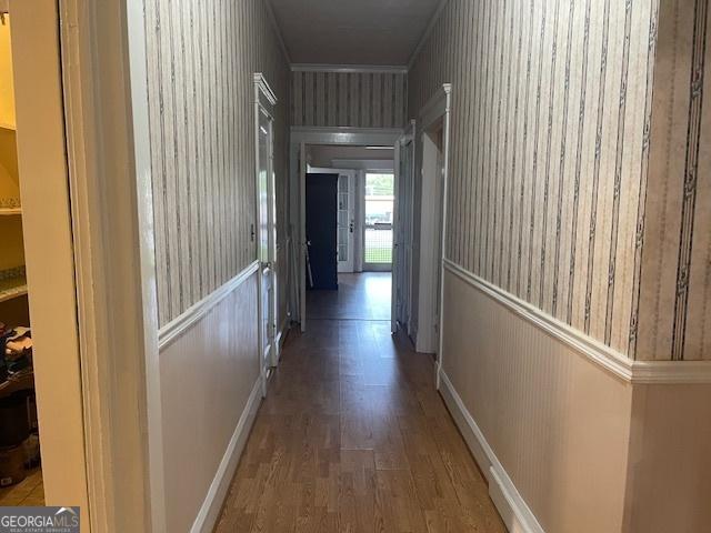 hall with baseboards and wood finished floors