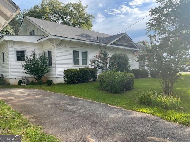 view of side of property with a yard and crawl space