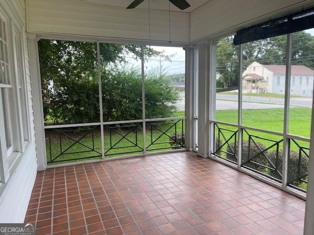 unfurnished sunroom featuring a ceiling fan