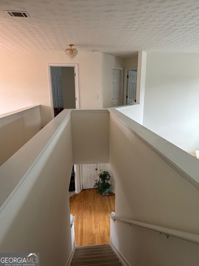 stairway featuring hardwood / wood-style floors and a textured ceiling