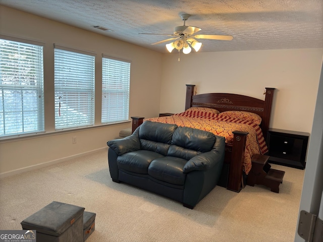 bedroom featuring ceiling fan, carpet floors, and a textured ceiling