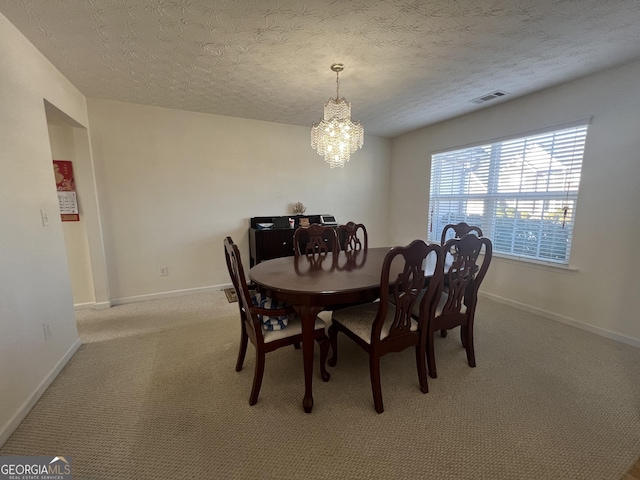 dining space featuring carpet flooring, a textured ceiling, and a notable chandelier