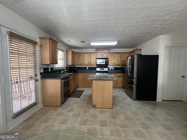 kitchen featuring appliances with stainless steel finishes, a center island, and sink