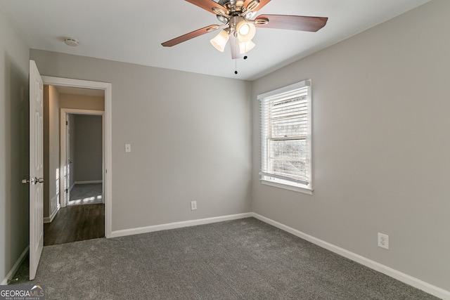 unfurnished room featuring ceiling fan and dark colored carpet