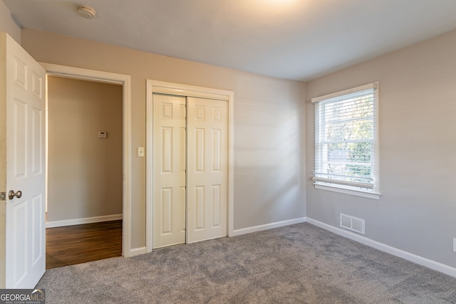 unfurnished bedroom featuring carpet and a closet