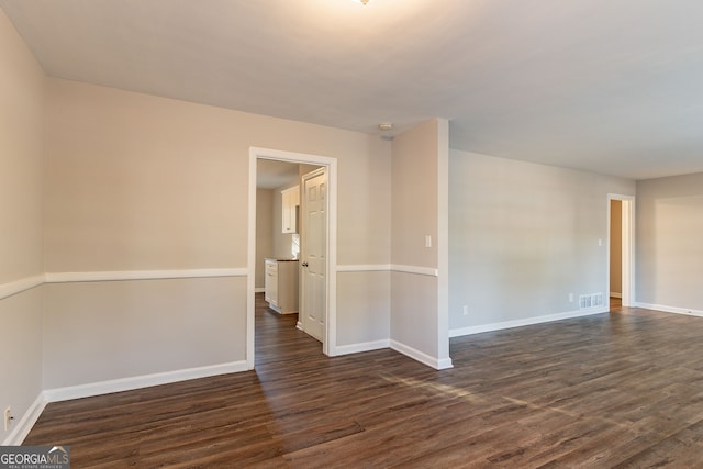 unfurnished room with dark hardwood / wood-style flooring