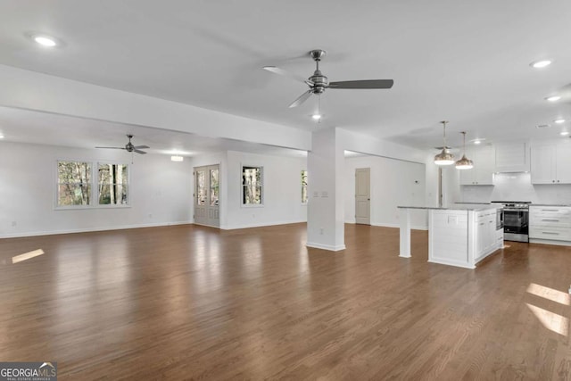 unfurnished living room featuring dark hardwood / wood-style floors and ceiling fan