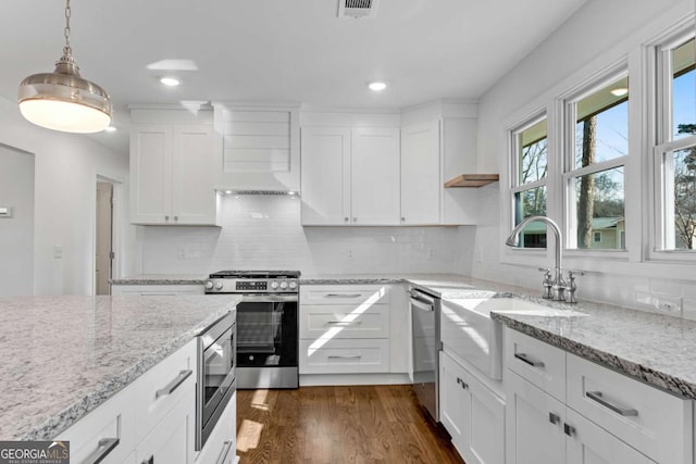 kitchen with white cabinetry, light stone countertops, decorative light fixtures, and stainless steel appliances