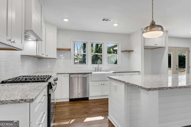 kitchen with pendant lighting, sink, dark wood-type flooring, stainless steel appliances, and white cabinets