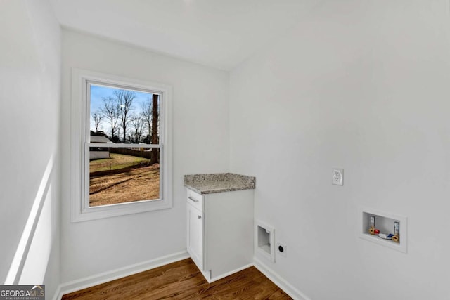 laundry room featuring electric dryer hookup, washer hookup, dark hardwood / wood-style flooring, and cabinets