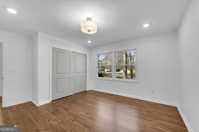 unfurnished bedroom featuring wood-type flooring and a closet