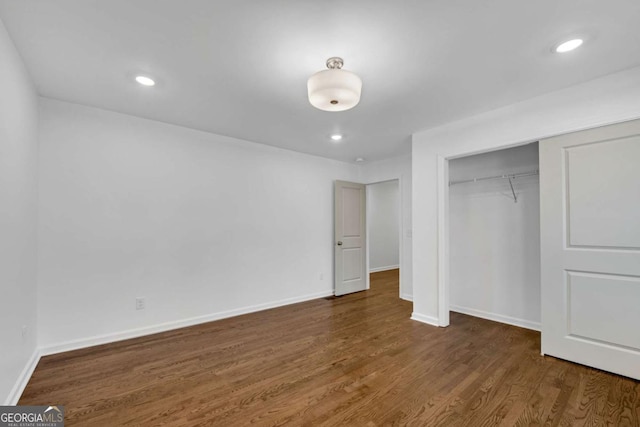 unfurnished bedroom featuring dark hardwood / wood-style flooring and a closet