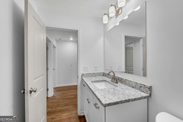 bathroom featuring vanity, hardwood / wood-style floors, and toilet