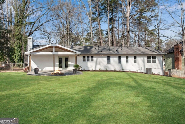 rear view of house featuring central AC, french doors, a patio area, a lawn, and a fire pit