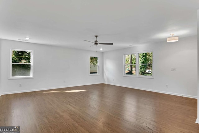 empty room with dark hardwood / wood-style flooring and ceiling fan