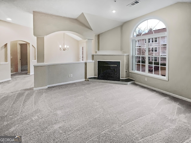 unfurnished living room with an inviting chandelier, light colored carpet, and lofted ceiling