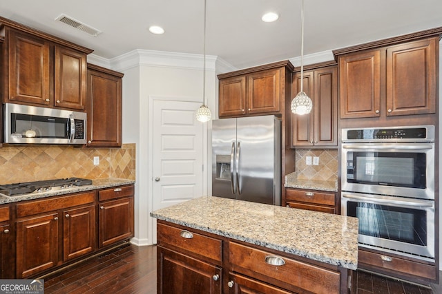 kitchen with visible vents, dark wood finished floors, stainless steel appliances, crown molding, and pendant lighting