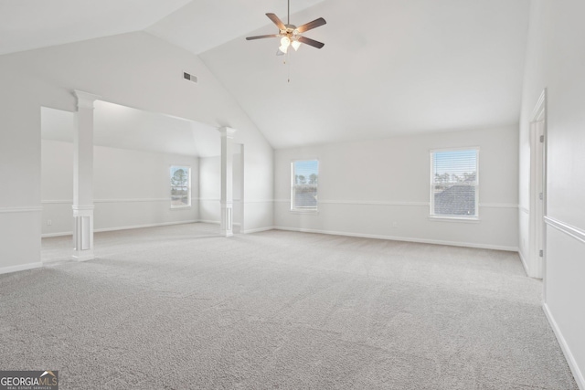 empty room featuring visible vents, a wealth of natural light, light carpet, and decorative columns