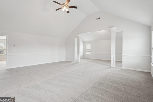 unfurnished living room featuring decorative columns, visible vents, a ceiling fan, light carpet, and vaulted ceiling