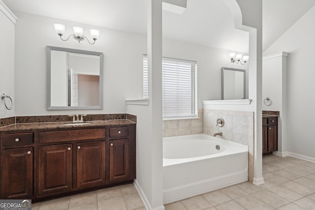 bathroom featuring baseboards, tile patterned flooring, vaulted ceiling, vanity, and a bath