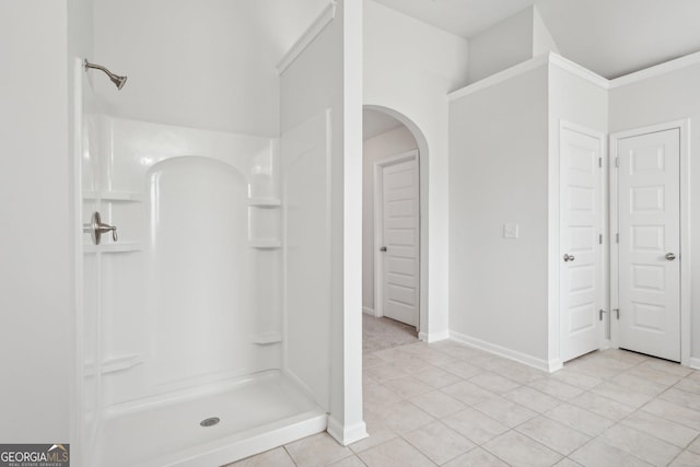 full bathroom with a stall shower, a closet, tile patterned flooring, and baseboards