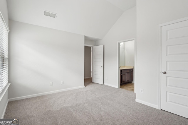 unfurnished bedroom with light carpet, multiple windows, visible vents, and vaulted ceiling