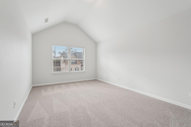 additional living space featuring lofted ceiling, light carpet, visible vents, and baseboards