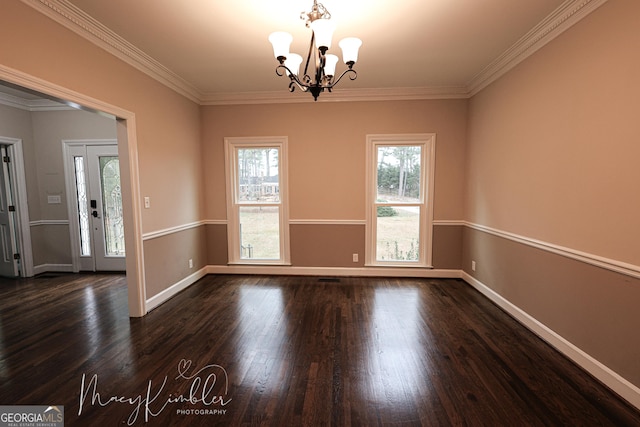 empty room with crown molding, dark wood-type flooring, and a chandelier