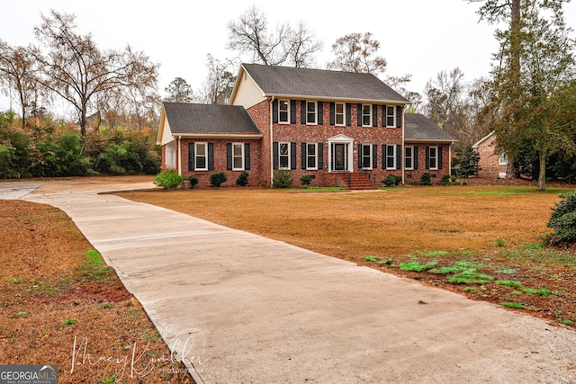 4804 Brittany Dr, Macon, GA 31210 - colonial home with concrete driveway, brick siding, a front yard, and roof with shingles