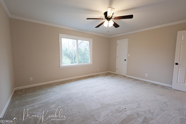 carpeted empty room featuring ceiling fan and ornamental molding