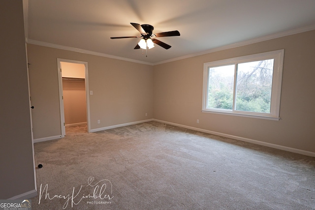 carpeted spare room featuring ornamental molding and ceiling fan