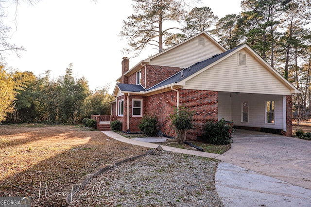 4804 Brittany Dr, Macon, GA 31210 - view of home's exterior with driveway, a chimney, brick siding, and an attached carport