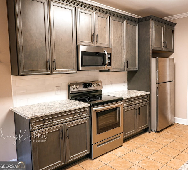 4804 Brittany Dr, Macon, GA 31210 - kitchen with stainless steel appliances, tasteful backsplash, light tile patterned floors, light stone counters, and crown molding
