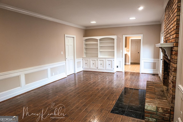 unfurnished living room with ornamental molding, hardwood / wood-style floors, and a brick fireplace