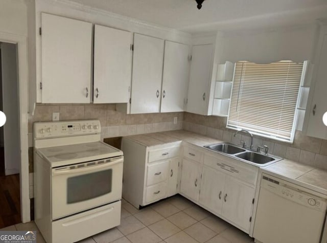 kitchen with sink, tile countertops, white cabinets, and white appliances