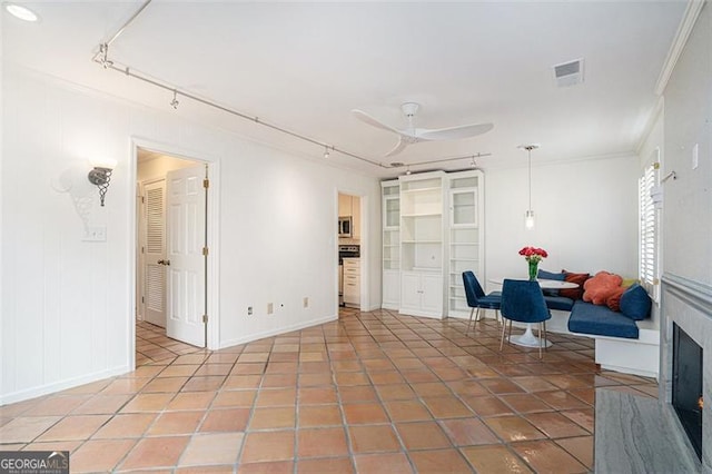 living area with crown molding, ceiling fan, tile patterned floors, and rail lighting