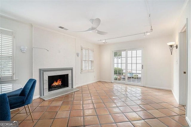 unfurnished living room featuring crown molding, track lighting, tile patterned floors, and ceiling fan