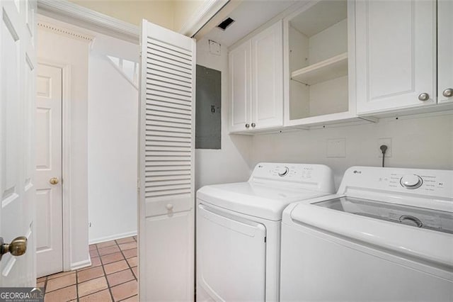 laundry room with cabinets, light tile patterned floors, and washing machine and clothes dryer