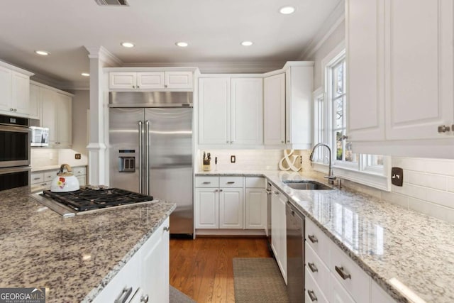 kitchen with sink, light stone counters, appliances with stainless steel finishes, dark hardwood / wood-style floors, and white cabinets