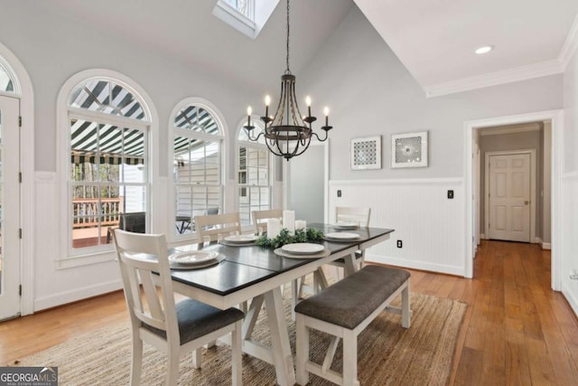 dining space featuring hardwood / wood-style floors, a notable chandelier, and vaulted ceiling