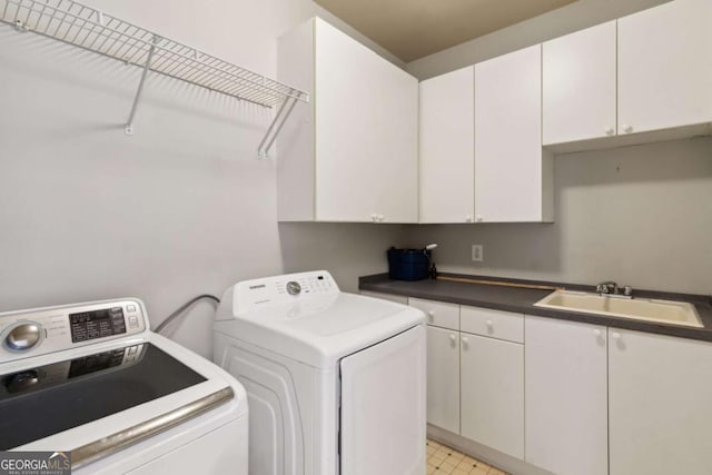 laundry area featuring cabinets, separate washer and dryer, and sink