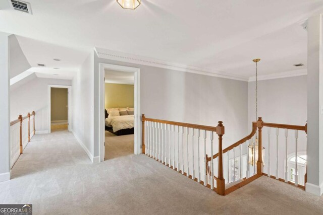 corridor featuring crown molding and light colored carpet