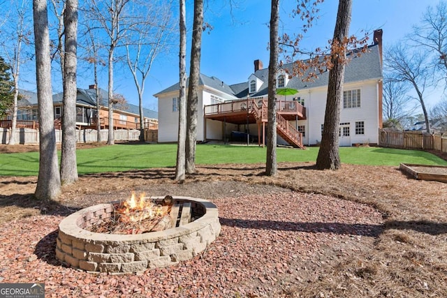 view of yard featuring a wooden deck and a fire pit