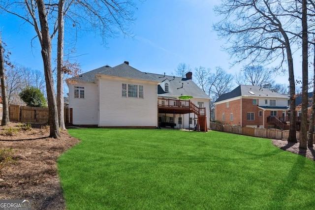 rear view of property with a wooden deck and a lawn