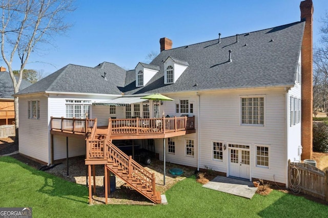 rear view of house with a deck and a lawn