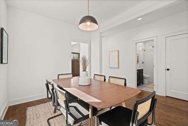 dining space featuring wood finished floors and baseboards
