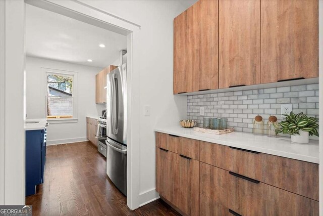 kitchen featuring dark wood-type flooring, baseboards, light countertops, decorative backsplash, and modern cabinets