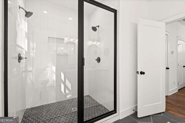 bathroom with tile patterned floors and a stall shower